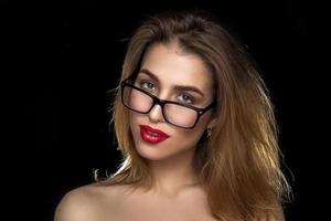 Frau mit Brille und roten Lippen im Studio foto