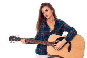 Wunderschönes brünettes Mädchen, das Gitarre spielt foto
