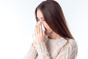 Mädchen wurde krank und hält ein Taschentuch in die Nähe der Nase foto