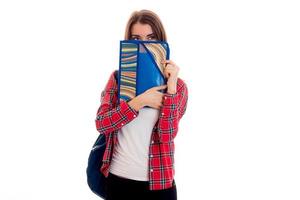 junge schöne Studentin mit Rucksack und Ordnern für Notizbücher posiert isoliert auf weißem Hintergrund im Studio foto