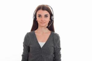 Porträt eines niedlichen brünetten Call-Center-Arbeitermädchens mit Kopfhörern und Mikrofon isoliert auf weißem Hintergrund foto