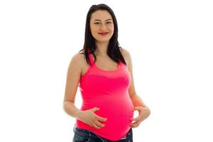 Junge lächelnde schwangere Frau schaut in die Kamera und lächelt foto
