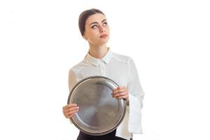schöne nachdenkliche Kellnerin hält ein großes rundes Tablett und blickt nach oben foto