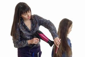 junge Frau trocknet Haare kleines Mädchen foto