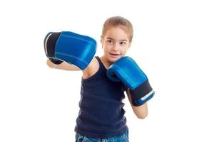 junges sportmädchen, das boxen in blauen handschuhen übt foto