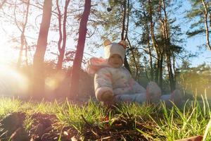 Fröhliches kleines Mädchen spielt mit Zapfen im Wald foto