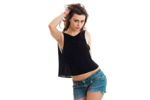 Brunette Teen in Jeans-Shorts und einem schwarzen T-Shirt sexy Posen vor der Kamera foto