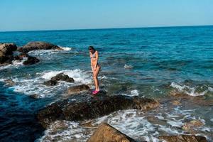 junges Mädchen, das sich im Sommer am Meer amüsiert foto