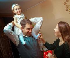 glückliches familienspiel mit kleinem mädchen zu hause foto