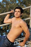 junger hispanischer Mann ohne Hemd auf die Tribüne, um seine muskulöse Brust zu zeigen. foto