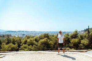 Guy steht auf dem Hügel mit Blick auf die Stadt foto