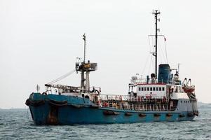 Altes rostiges Schiff, das in einen Hafen einfährt foto