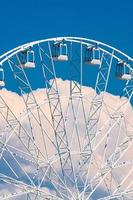 großes Riesenrad gegen blauen Himmel und weiße Wolken foto