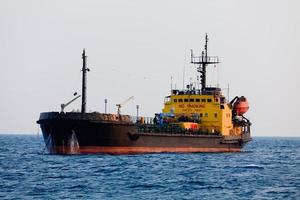 Schwarzer Tanker liegt in der Nähe des Hafens vor Anker foto