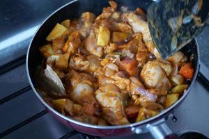 Hühnercurry in einer Kochpfanne kochen foto