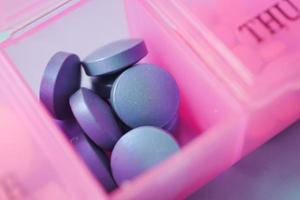 Nahaufnahme von blauen medizinischen Pillen in einer Pillendose foto