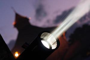 Lichtscheinwerfer, bei einem Konzert von der Bühne auf dem Hintergrund eines Hauses bei Nacht. foto