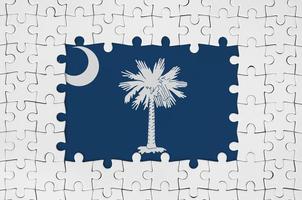 South Carolina US-Staatsflagge im Rahmen aus weißen Puzzleteilen mit fehlendem Mittelteil foto