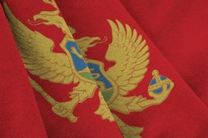 montenegro-flagge mit großen falten, die unter dem studiolicht im innenbereich wehen. die offiziellen symbole und farben im banner foto