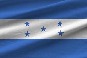 honduras-flagge mit großen falten, die nah oben unter dem studiolicht drinnen winken. die offiziellen symbole und farben im banner foto