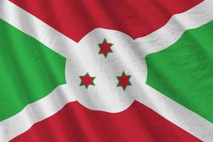 Burundi-Flagge mit großen Falten, die im Innenbereich unter dem Studiolicht wehen. die offiziellen symbole und farben im banner foto