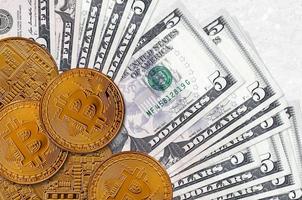 5 US-Dollar-Scheine und goldene Bitcoins. kryptowährungsinvestitionskonzept. Krypto-Mining oder -Handel foto