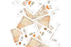10 britische Pfund-Scheine, die isoliert auf Weiß herunterfliegen. viele banknoten fallen mit weißem copyspace auf der linken und rechten seite foto