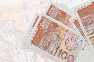 100 kroatische Kuna-Scheine liegen im Stapel auf dem Hintergrund einer großen halbtransparenten Banknote. abstrakte Darstellung der Landeswährung foto