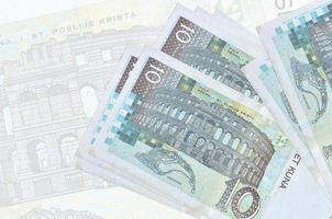 10 kroatische Kuna-Scheine liegen im Stapel auf dem Hintergrund einer großen halbtransparenten Banknote. abstrakte Darstellung der Landeswährung foto