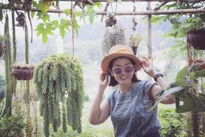 Fröhliche asiatische Frau, die vor Glück im heimischen Garten lächelt foto