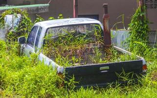 Schrottautowracks, die in den Büschen auf Phuket, Thailand, verrotten. foto