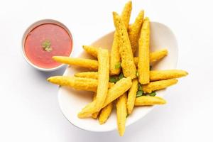 Knusprig frittierte Baby-Mais-Pakoda, Pakora oder Baby-Mais-Krapfen, serviert mit Ketchup, indisches Essen foto