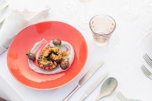 Oktopus mit Gemüsesalat auf weißem Teller mit Aperitif. kulinarisches Servieren von Speisen in Restaurants. Gourmet-Platte mit Meeresfrüchten foto