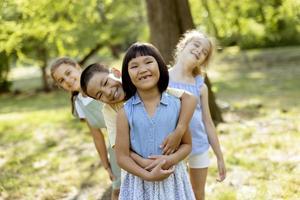 gruppe asiatischer und kaukasischer kinder, die spaß im park haben foto