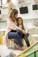 Kindergärtnerin spricht mit kleinem Mädchen im Kindergarten foto