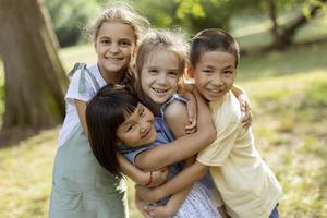 gruppe asiatischer und kaukasischer kinder, die spaß im park haben foto