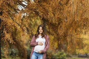 junge schwangere Frau im Herbstpark foto