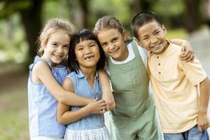 gruppe asiatischer und kaukasischer kinder, die spaß im park haben foto