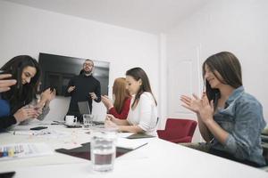 Executive Leader im Gespräch mit einer glücklichen, vielfältigen Mitarbeitergruppe bei einer Unternehmensbürobesprechung, foto