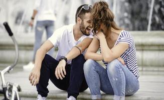 ein paar touristen, die spaß haben, im urlaub auf der straße der stadt spazieren zu gehen - glückliche freunde, die im urlaub zusammen lachen - menschen- und urlaubskonzept foto