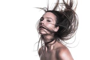 Porträt einer schönen Frau mit langen Haaren. junge Brünette Modell mit schönen Haaren - isoliert auf weißem Hintergrund. junges Mädchen mit Haaren, die im Wind fliegen. foto