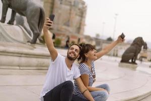 ein paar touristen, die spaß haben, im urlaub auf der straße der stadt spazieren zu gehen - glückliche freunde, die im urlaub zusammen lachen - menschen- und urlaubskonzept foto