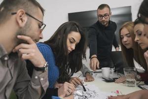 Executive Leader im Gespräch mit einer glücklichen, vielfältigen Mitarbeitergruppe bei einer Unternehmensbürobesprechung, foto