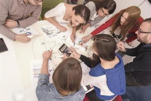 Executive Leader im Gespräch mit einer glücklichen, vielfältigen Mitarbeitergruppe bei einer Unternehmensbürobesprechung, foto