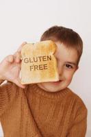 Vorschuljunge mit geröstetem Brot ohne Gluten. gesundes Essen. Glutenunverträglichkeit bei Kindern. foto