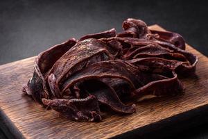 köstliches gesalzenes getrocknetes Rindfleisch in Scheiben geschnitten als Vorspeise für Bier foto