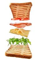 Frisches Sandwich mit fliegenden Zutaten auf weißem Hintergrund isoliert foto
