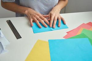 DIY-Konzept. Frau macht Origami-Osterhasen aus farbigem Papier. Origami-Unterricht foto