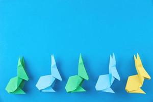 Papierfarbene Origami-Esater-Kaninchen auf blauem Hintergrund foto