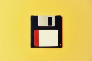 schwarze Diskette auf gelbem Hintergrund. Vintage Computerdiskette, Nahaufnahme foto